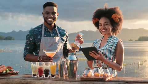 a man and woman making cocktails with mixology course